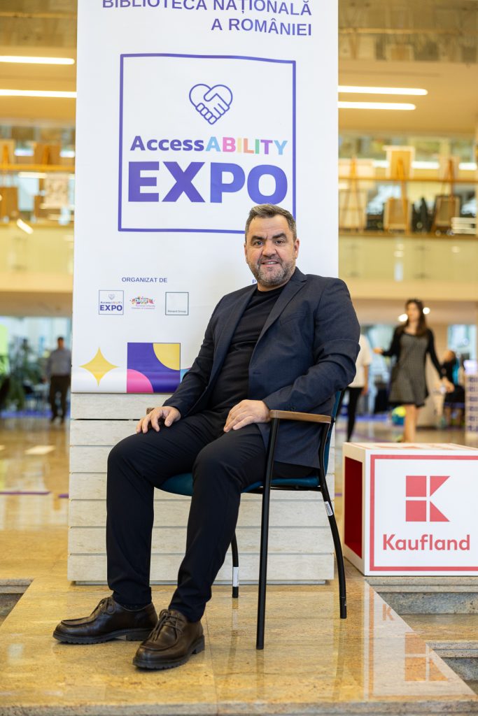 Stefan Catalin Sfeatcu standing in front of a banner saying AccessABILITY Expo - only just seen