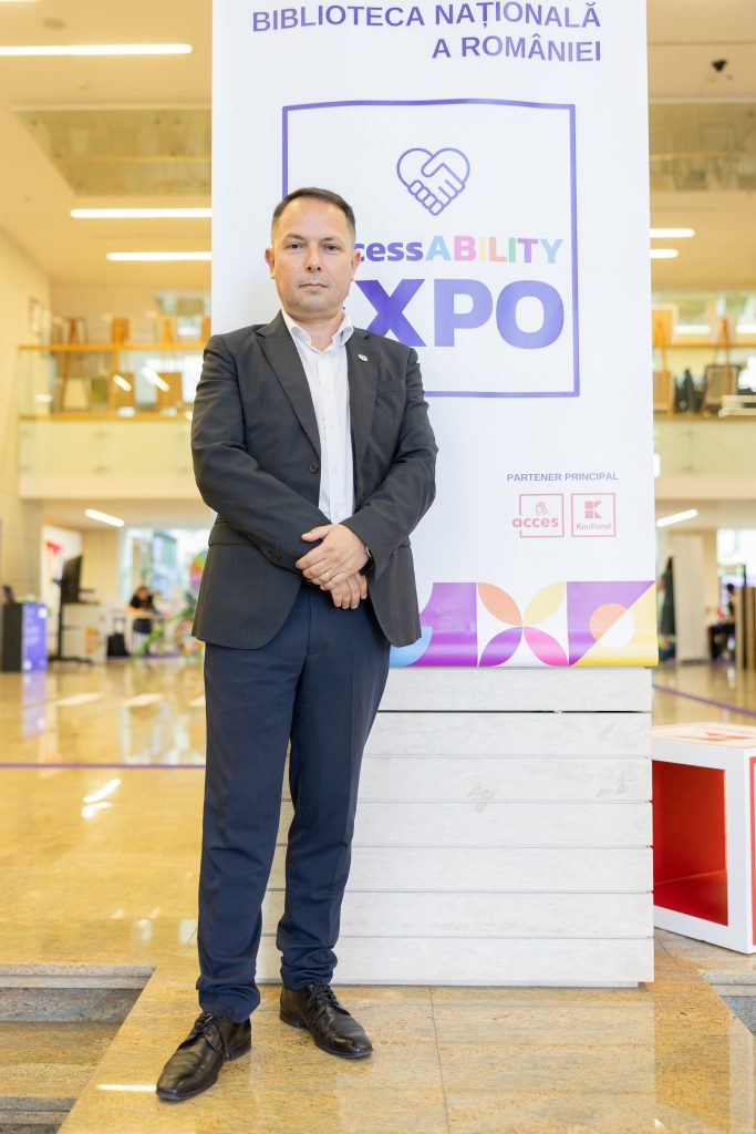 Tudor Scripor standing in front of a banner saying AccessABILITY Expo