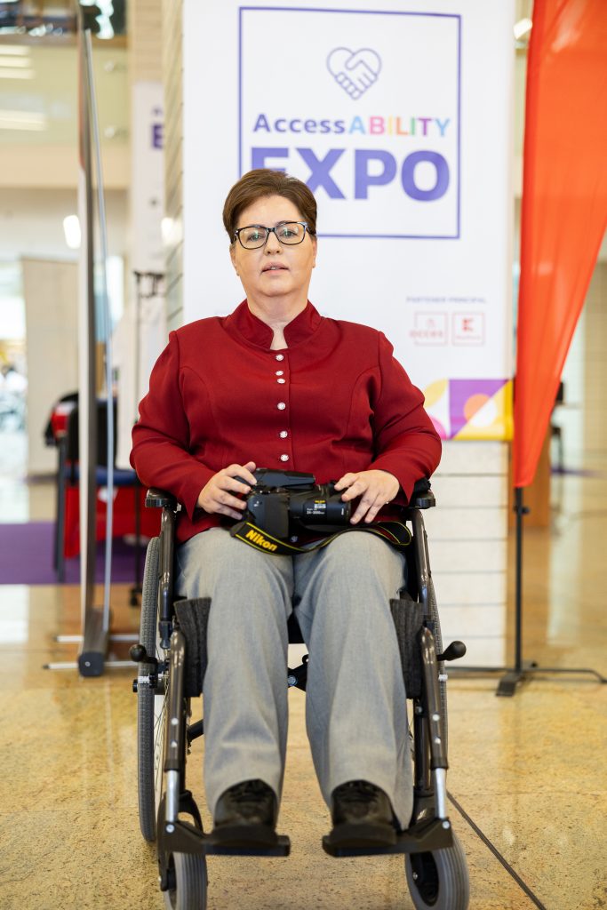 Daniela Tontsch in a wheelchair in front of a banner saying AccessABILITY Expo